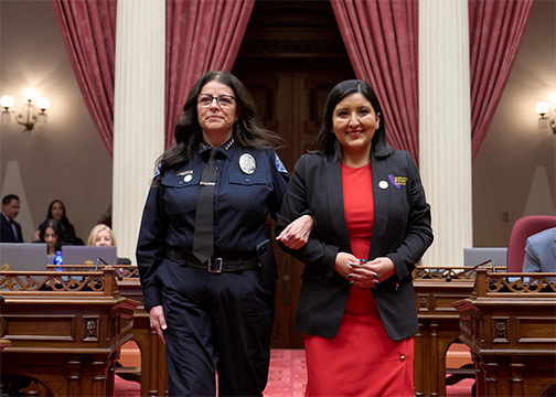 Senator Melissa Hurtado (right), walks arm in arm with her Senate District 16 Woman of the Year honoree, Corcoran Police Chief Margarita "Maggie" Ochoa, during a ceremony at the State Capitol. 